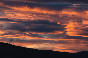 Fototapeta na wymiar sunset sky with pink and orange clouds over the mountains