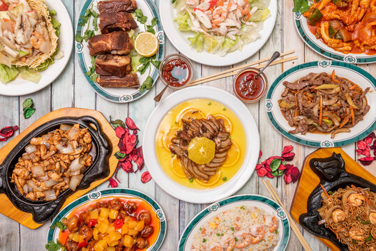 Top view image of popular Chinese dish set of orange duck, tres delicias rice with prawns, fried ribs, sweet and sour pork, beef with bamboo and mushroom shiitake