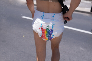 Man's legs in white diaper with colors of rainbow back view. Symbol of gays is colors of rainbow....