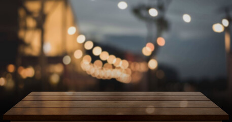 Empty wooden table top with lights bokeh on blur restaurant background.
