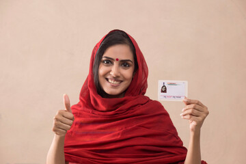 Portrait of a woman standing with her aadhar card.