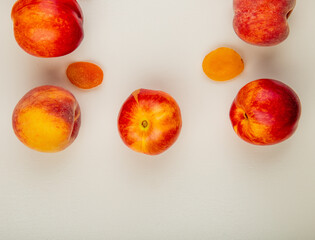top view of fresh ripe nectarines and peaches with dried apricots on white background