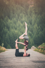 giovane coppia pratica acroyoga all'aperto in natura. Acroyoga. Coppia yoga. Partner yoga