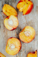 top view of halves of fresh ripe nectarines on a wooden rustic background