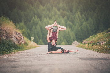 giovane coppia pratica acroyoga all'aperto in natura. Acroyoga. Coppia yoga. Partner yoga