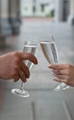 Glasses with champagne in the hands of the bride and groom. Close-up wine.