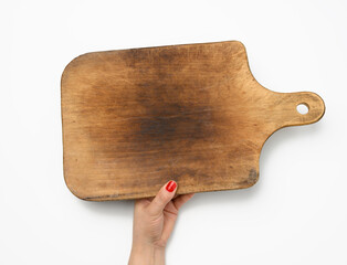 female hand with red manicure holds blank old vintage rectangular kitchen chopping board on white background