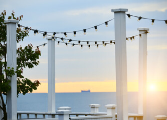 Dawn at sea . Cozy deserted cafe by the sea at dawn. Wooden terrace overlooking the sea
