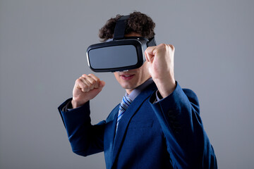 Caucasian businessman wearing vr headset, isolated on grey background