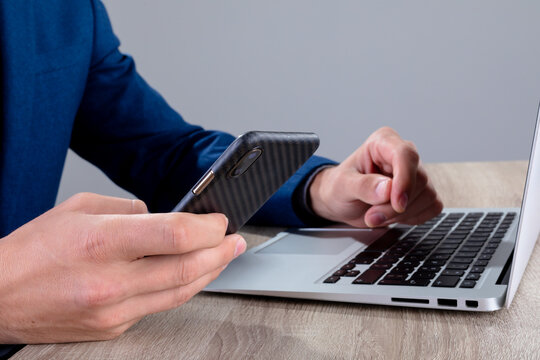 Midsection of caucasian businessman using smartphone and laptop, isolated on grey background - Powered by Adobe