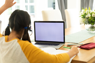 Fototapeta na wymiar Asian girl using laptop with blank screen at home