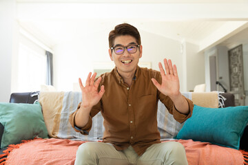Obraz premium Asian man smiling during video call at home