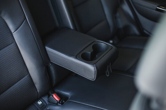 car cup holders between back seats, close up view, luxury car interior