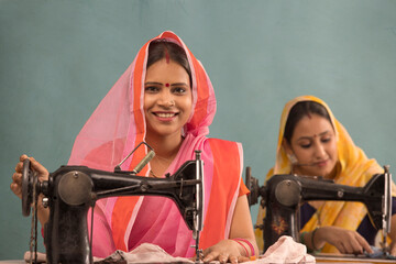 Two rural women working together on sewing machines. - obrazy, fototapety, plakaty