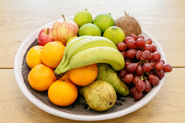 A bowl of juicy fruits sits on a table.