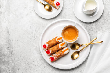 Breakfast with Italian pastry cannoli with ricotta cream. Coffee cup,  on white stone background. Copy space.