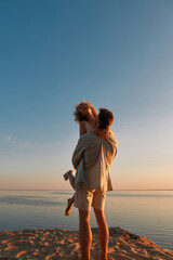 Fototapeta premium Attractive young caucasian man raising happy girlfriend