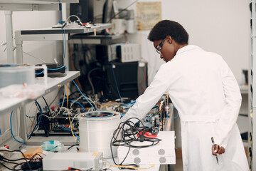 Scientist african american woman working in laboratory and single photon decoder encoder fiber...