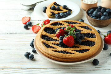 Concept of delicious dessert with blueberry pie on white wooden table