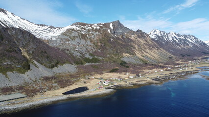 Obraz premium majestic blue fjord surrounded by mighty mountains on the island of senja in the small fishing village of Grunnfarnes, northern Norway in summer, aerial shot