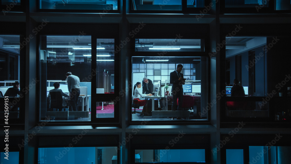 Poster shot from outside the window: businessmen and businesswomen working in the office. managers and spec