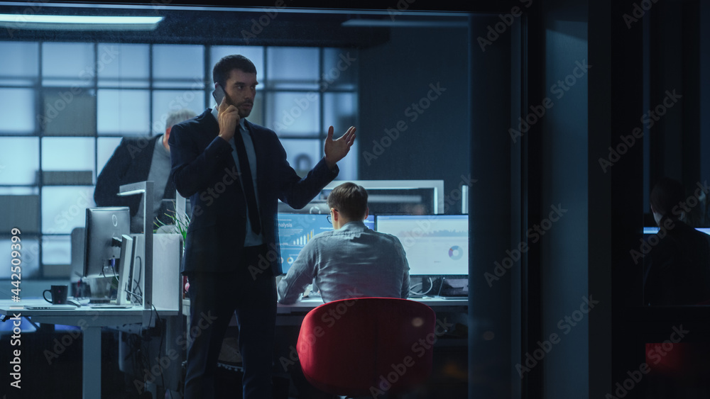 Poster Shot from Outside: Businessman Talking on a Mobile in the Office. Manager is Having a Business Call while Standing by the Window. Employee Planning Financial Tasks and Business Development.