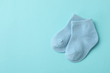 Pair of cute baby socks on blue background