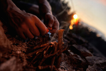 Close up of male hands making a fire with flint and steel in the wild