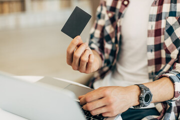 man holding credit card and using laptop, concept of online shopping, online payment