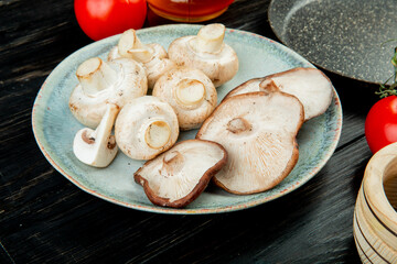 side view of fresh mushrooms on a blue plate on rustic wooden background