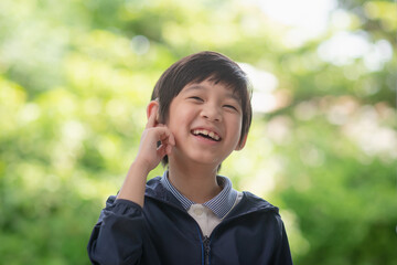 Asian child with hearing aid on nature background