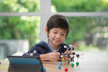 child constructing molecular model  in science classroom