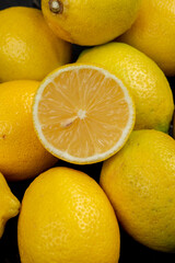 side view of fresh ripe lemons on black background