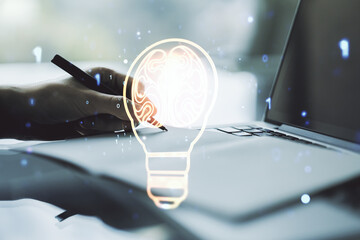 Creative idea concept with light bulb and human brain illustration and with hand writing in notebook on background with laptop. Neural networks and machine learning concept. Multiexposure