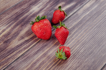side view of fresh ripe strawberries isolated on rustic wooden background