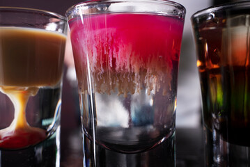 Barman preparing cocktail shots at the bar counter. Barman mixing drinks at the night club..