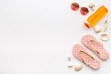 Layout of beach accessories with sun cosmetics, sunglasses and flip flops