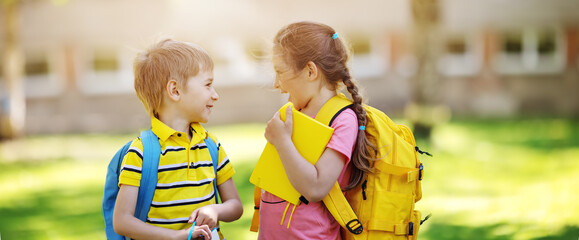 Two cute children standing in the schoolyard park - Powered by Adobe