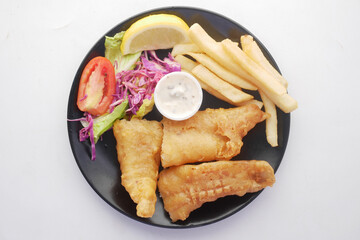 Fish fillet, lemon , chips and potato mash on table 