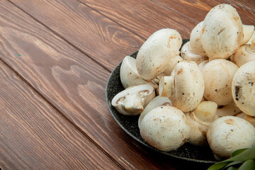 side view of fresh white mushrooms isolated on rustic wooden background with copy space