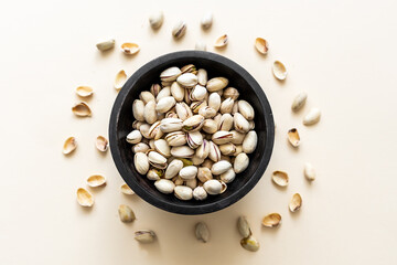 Draufsicht auf gröstete Pistazien in der Schale in einer Schüssel. Beiger Hintergrund. Nuss.