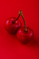 side view of red ripe cherry with water drops isolated on red background