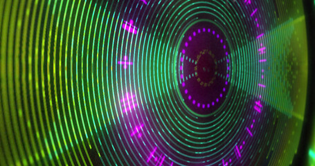 Image of circular green and pink 3d light display flashing and rotating on black background