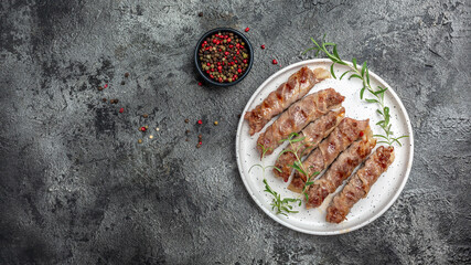Grilled meat rolls wrapped bacon, sausages of ground beef or pork with onions and spices wrapped in bacon, chevapchichi or Kofta kebab, Long banner format. top view