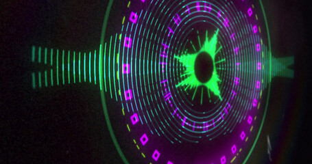 Image of circular green and pink 3d light display flashing and rotating on black background