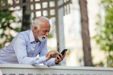 Fototapeta premium Mature man, searching through his mobile.