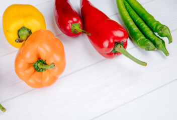 side view of various types of peppers bell peppers with green and red hot chili peppers on white background