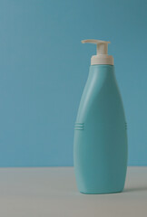 Empty blue mockup jar and cosmetic product dispenser bottle with white cap on blue background.