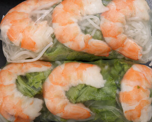 Vietnamese prawn shrimp see through rice paper spring roll green vegetable sauce on dark plate