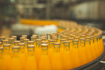 Beverage factory interior. Conveyor flowing with bottles for juice
